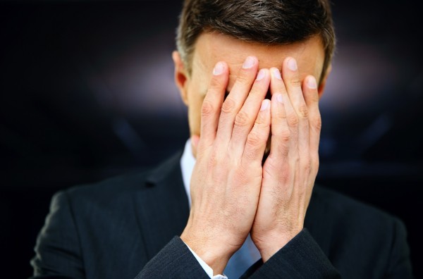 Frustrated businessman with hands on face
