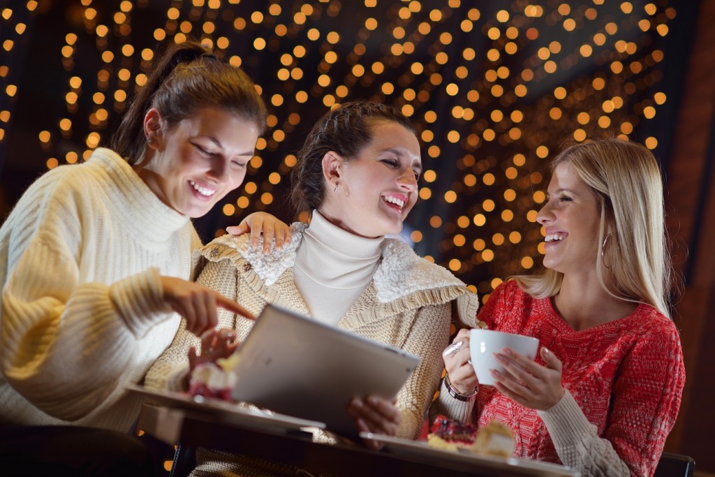 happy girls group looking at a pc tablet