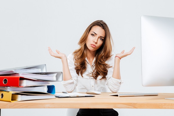 Young confused beautiful businesswoman shrugging shoulders